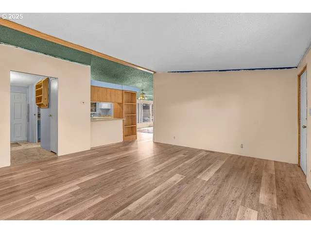 a kitchen with kitchen island a sink wooden floor and a refrigerator
