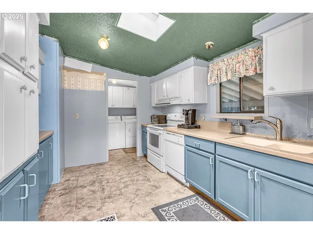 a kitchen with white cabinets and a refrigerator