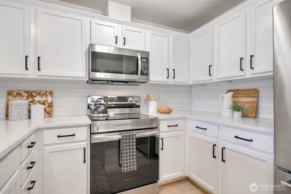a kitchen with granite countertop a sink and steel appliances