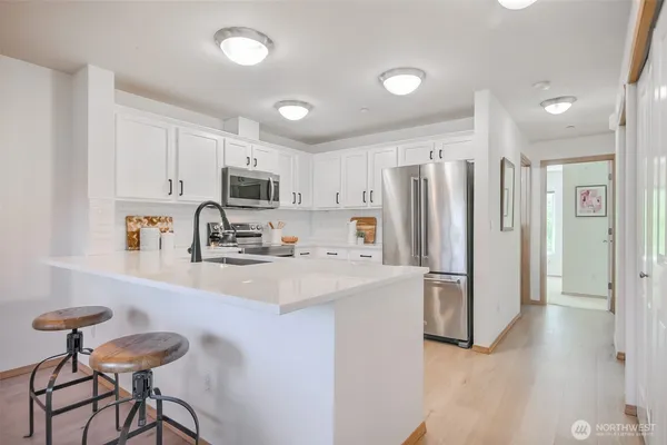 a kitchen with white cabinets and white appliances