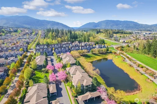 an aerial view of ocean and residential houses with outdoor space