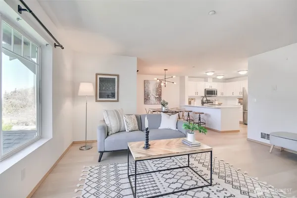 a living room with furniture a rug and a table
