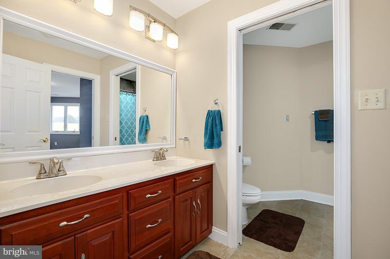4320 Valley View Road Middletown, MD 21769 - Photo 23 of 30 a spacious bathroom with a granite countertop sink a toilet a mirror and shower