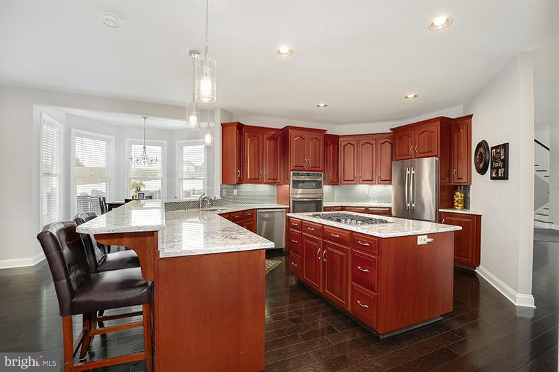 4320 Valley View Road Middletown, MD 21769 - Photo 8 of 30 a kitchen with stainless steel appliances granite countertop a stove a refrigerator a sink dishwasher with a dining table and chairs