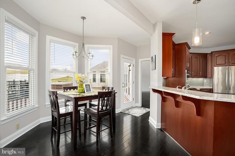 4320 Valley View Road Middletown, MD 21769 - Photo 10 of 30 a kitchen with stainless steel appliances granite countertop a stove a sink dishwasher a dining table and chairs with wooden floor