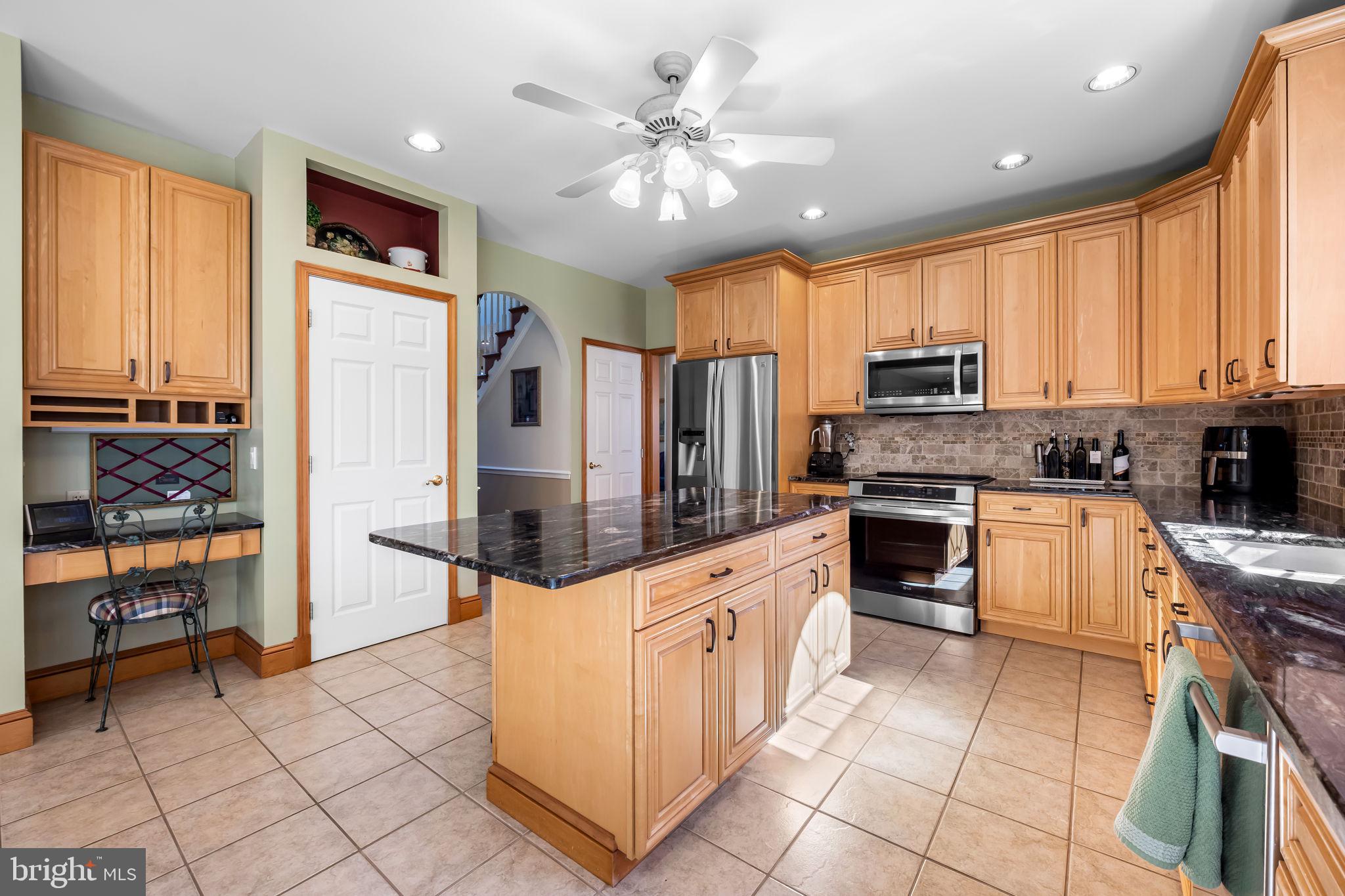 6815 Cherry Tree Court New Market, MD 21774 - Photo 16 of 86 a kitchen with stainless steel appliances kitchen island granite countertop a stove refrigerator and microwave