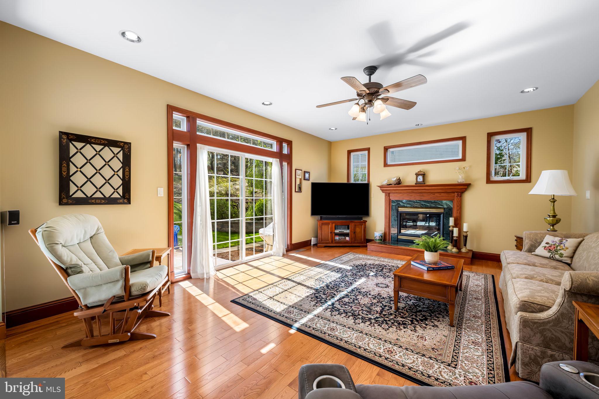 6815 Cherry Tree Court New Market, MD 21774 - Photo 22 of 86 a living room with furniture a flat screen tv and a fireplace