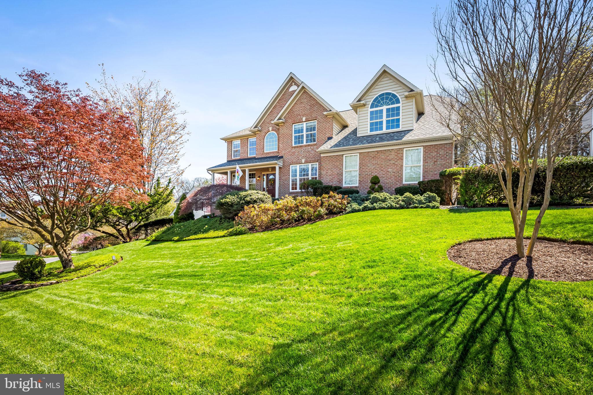 6815 Cherry Tree Court New Market, MD 21774 - Photo 3 of 86 a front view of a house with a garden and trees