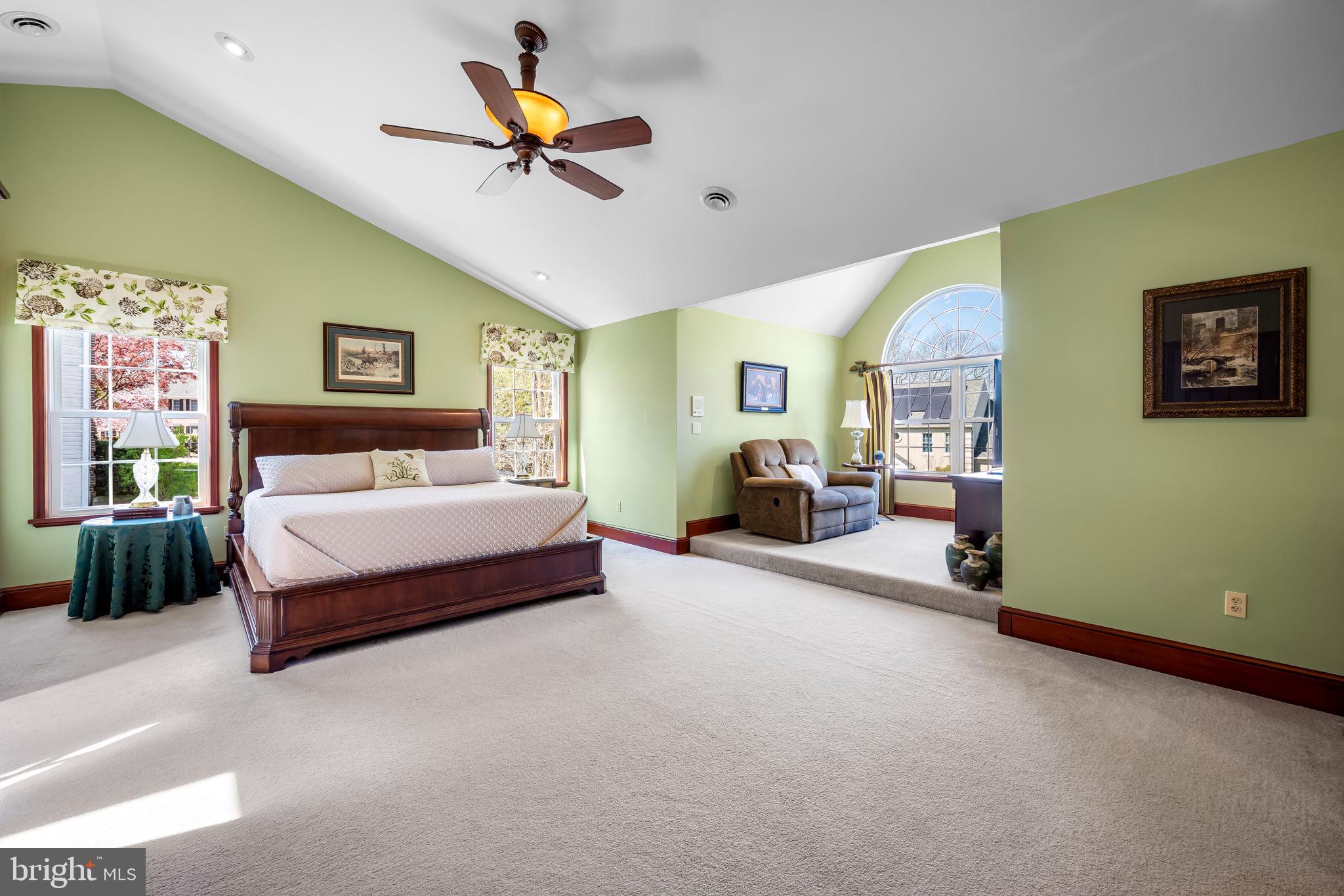 6815 Cherry Tree Court New Market, MD 21774 - Photo 42 of 86 a spacious bedroom with a bed a couch and a chandelier