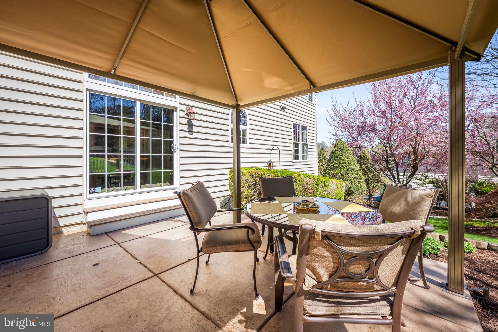 6815 Cherry Tree Court New Market, MD 21774 - Photo 62 of 86 a view of a patio with a table and chairs under an umbrella