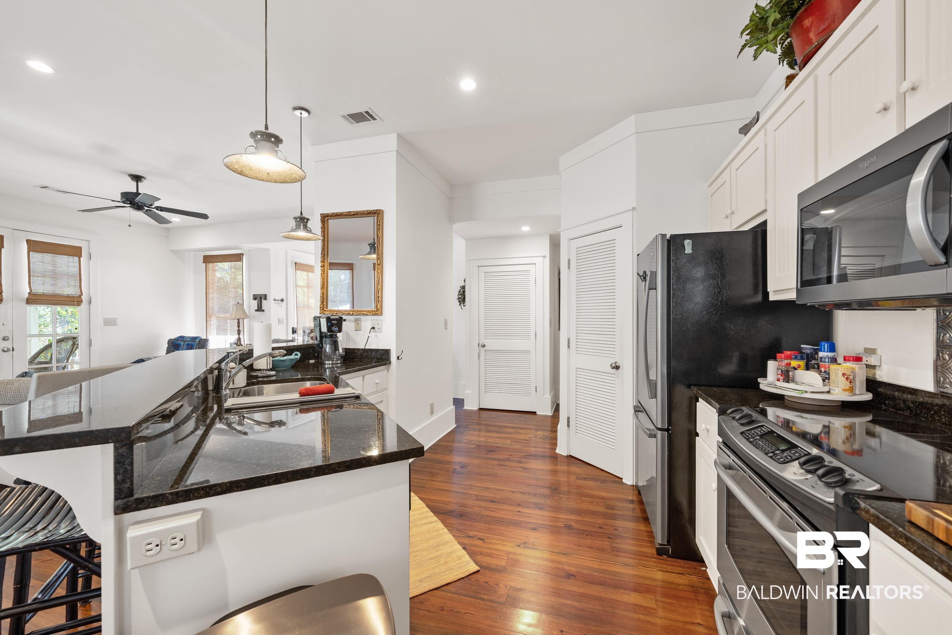 25773 Canal Road, Unit 10 Orange Beach, AL 36561 - Photo 8 of 40 Kitchen with sink, beautiful hardwood floors, decorative light fixtures and appliances with stainless steel finishes