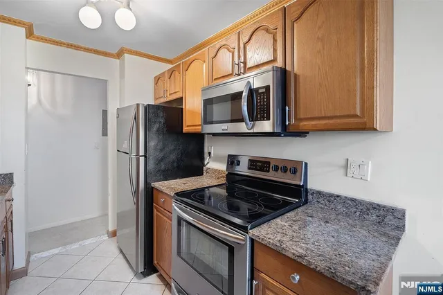 a kitchen with stainless steel appliances granite countertop a refrigerator and a stove top oven