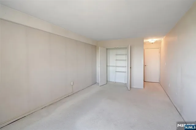 a view of an empty room and a kitchen