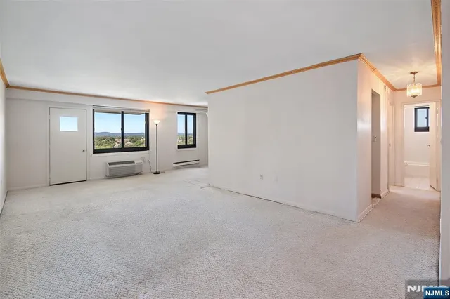 a view of a big room with windows and chandelier fan