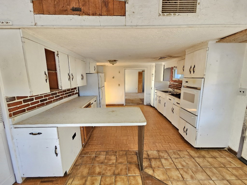 94 Clark Road Spencer, MA 01562 - Photo 7 of 17 a kitchen with kitchen island a stove a sink and a refrigerator
