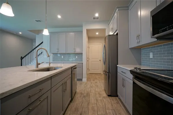 a kitchen with a sink stainless steel appliances and cabinets