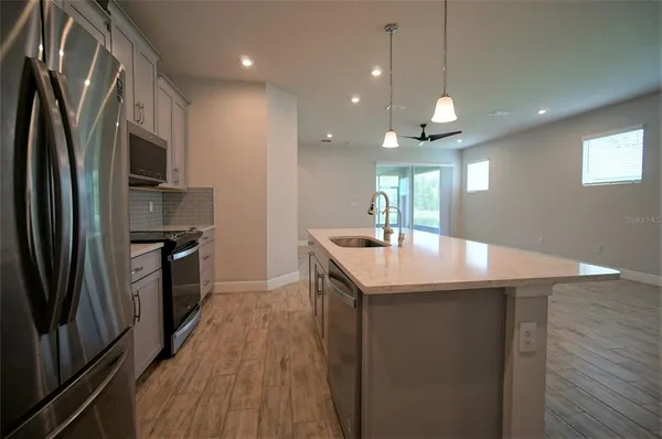 a kitchen with stainless steel appliances granite countertop a sink a refrigerator and a stove