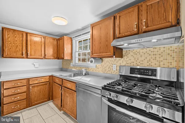 a kitchen with a sink stove top oven and cabinets