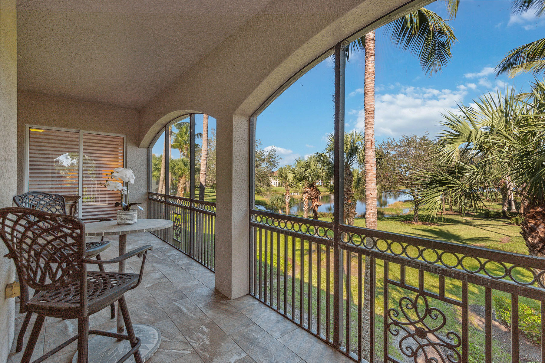 3189 Aviamar Circle, Unit 202 Naples, FL 34114 - Photo 1 of 50 a view of a chairs and table in patio with wooden fence