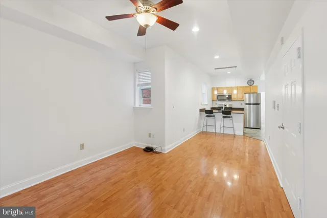 a view of a livingroom with a furniture wooden floor and a ceiling fan