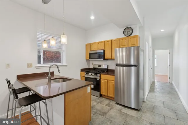 a kitchen with stainless steel appliances granite countertop a refrigerator a sink a stove and island