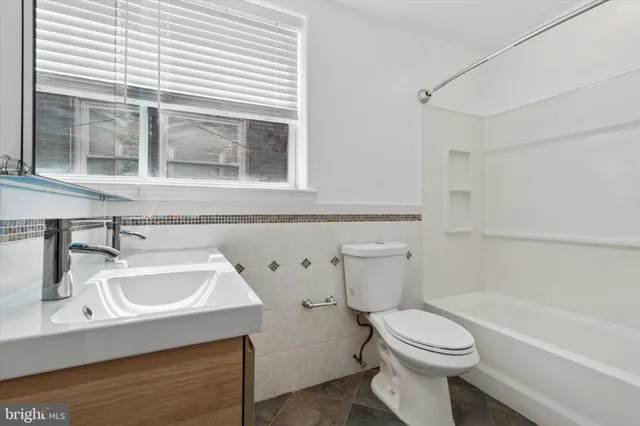 a bathroom with a sink a toilet and bathtub