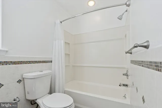 a bathroom with a shower a toilet and a bathtub