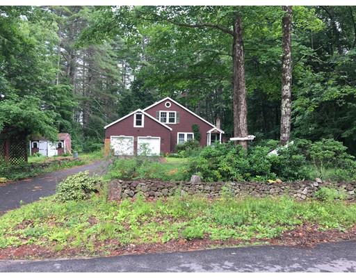 a front view of a house with a yard and potted plants