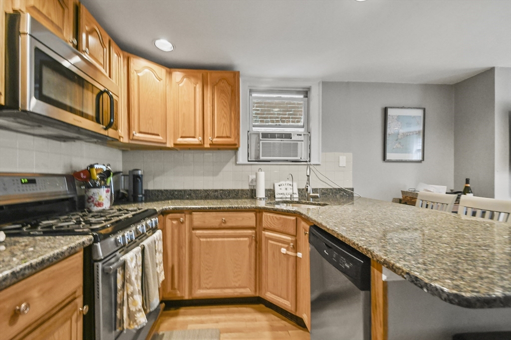 9 Allston Street, Unit 1 Boston, MA 02129 - Photo 7 of 19 a kitchen with stainless steel appliances granite countertop a sink stove and cabinets