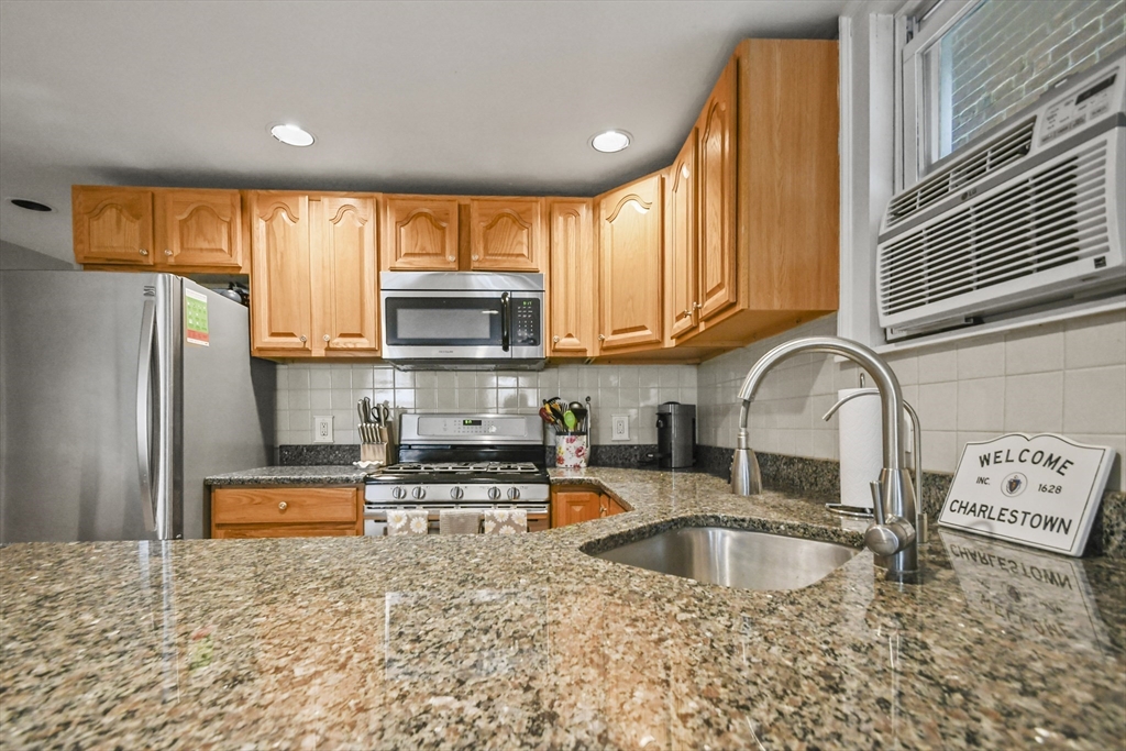 9 Allston Street, Unit 1 Boston, MA 02129 - Photo 10 of 19 a kitchen with stainless steel appliances granite countertop a sink a refrigerator and a stove top oven