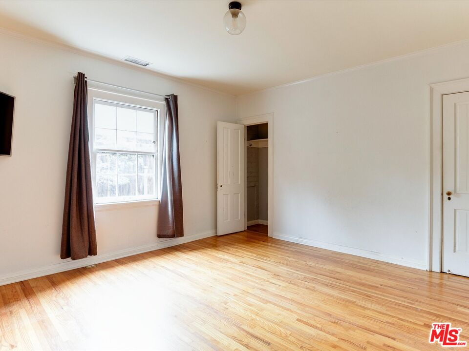 11729 Tennessee Avenue Los Angeles, CA 90064 - Photo 12 of 15 a view of an empty room with wooden floor and a window