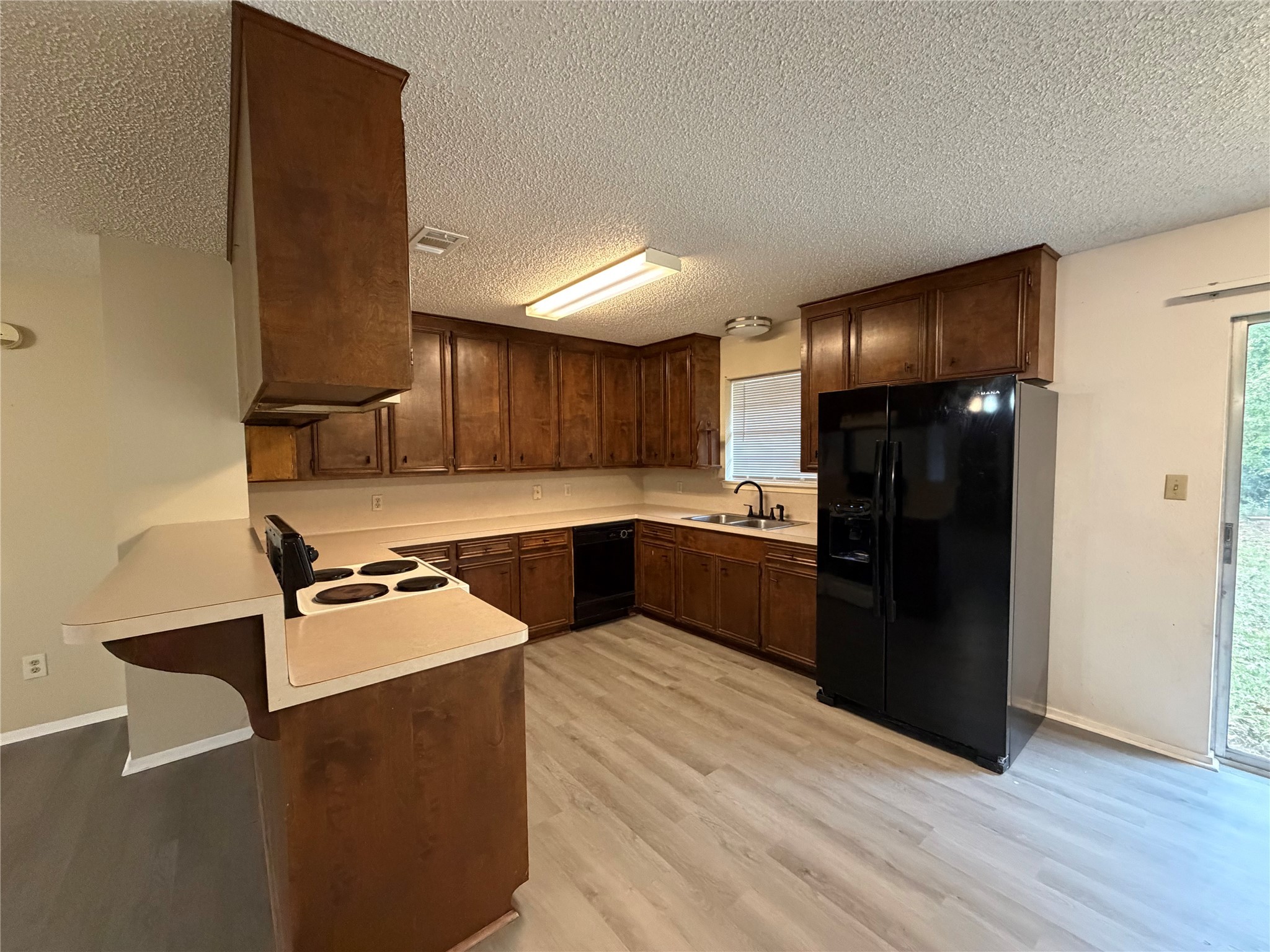 117 Kirk Road Livingston, TX 77351 - Photo 6 of 12 a kitchen with granite countertop a refrigerator stove and wooden cabinets