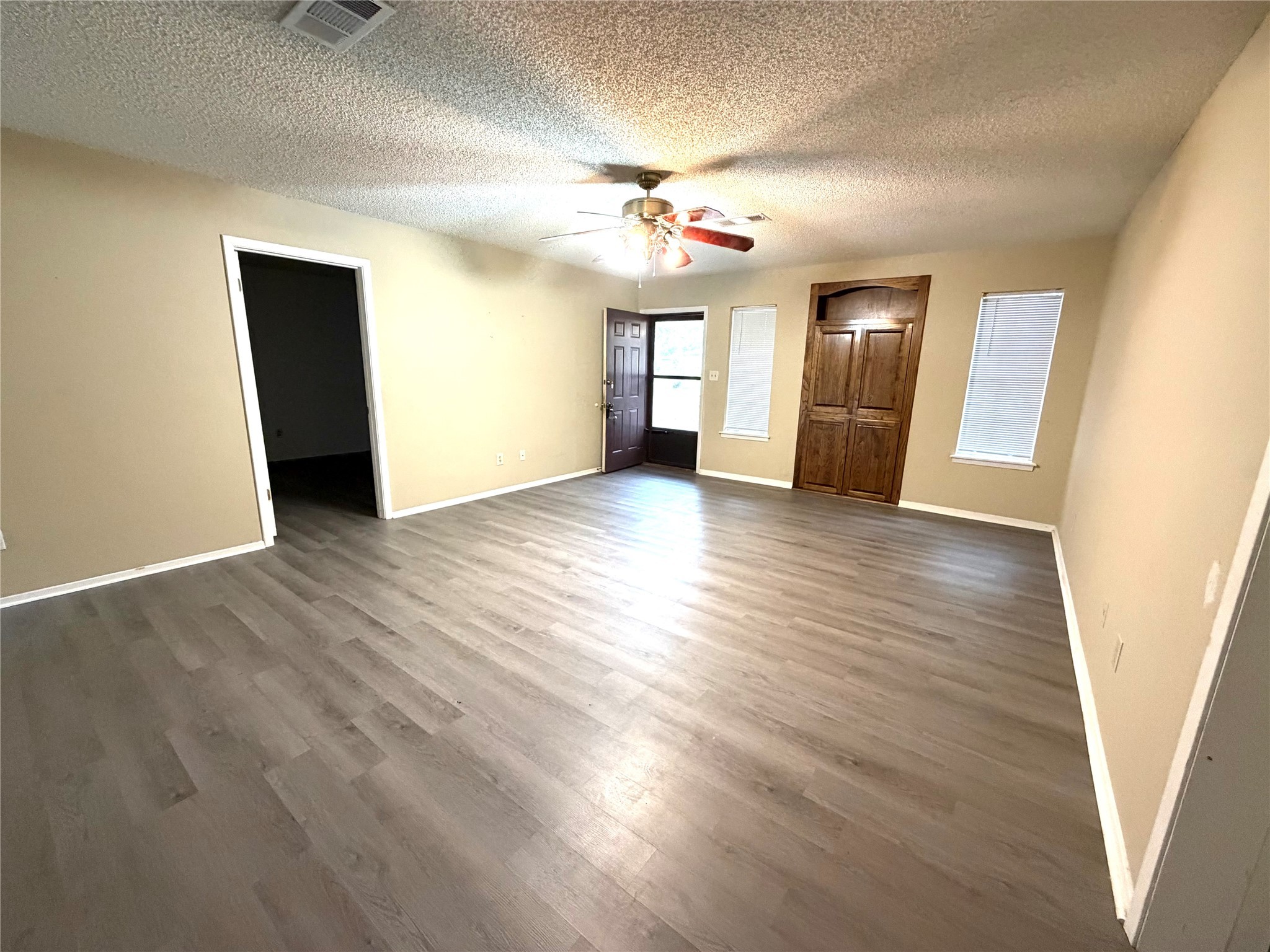117 Kirk Road Livingston, TX 77351 - Photo 7 of 12 an empty room with wooden floor and windows