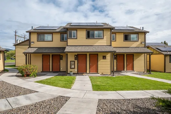 a front view of a house with a yard and trees