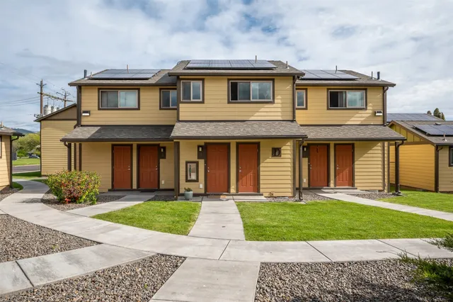 a front view of a house with a yard and trees