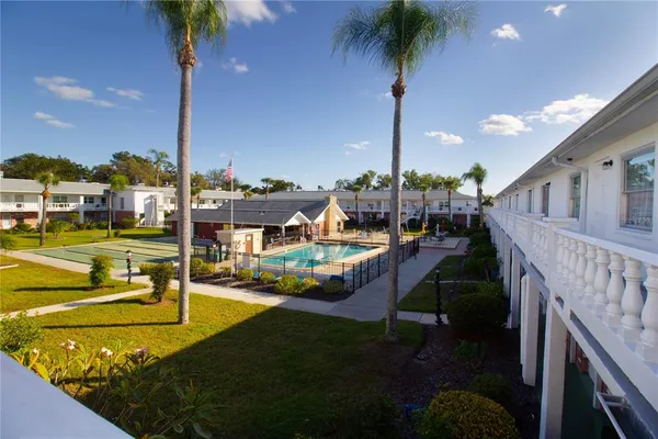 a view of a swimming pool with a patio and a yard