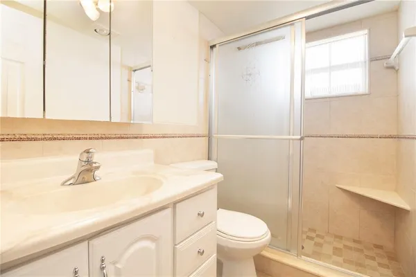a bathroom with a sink a toilet and shower