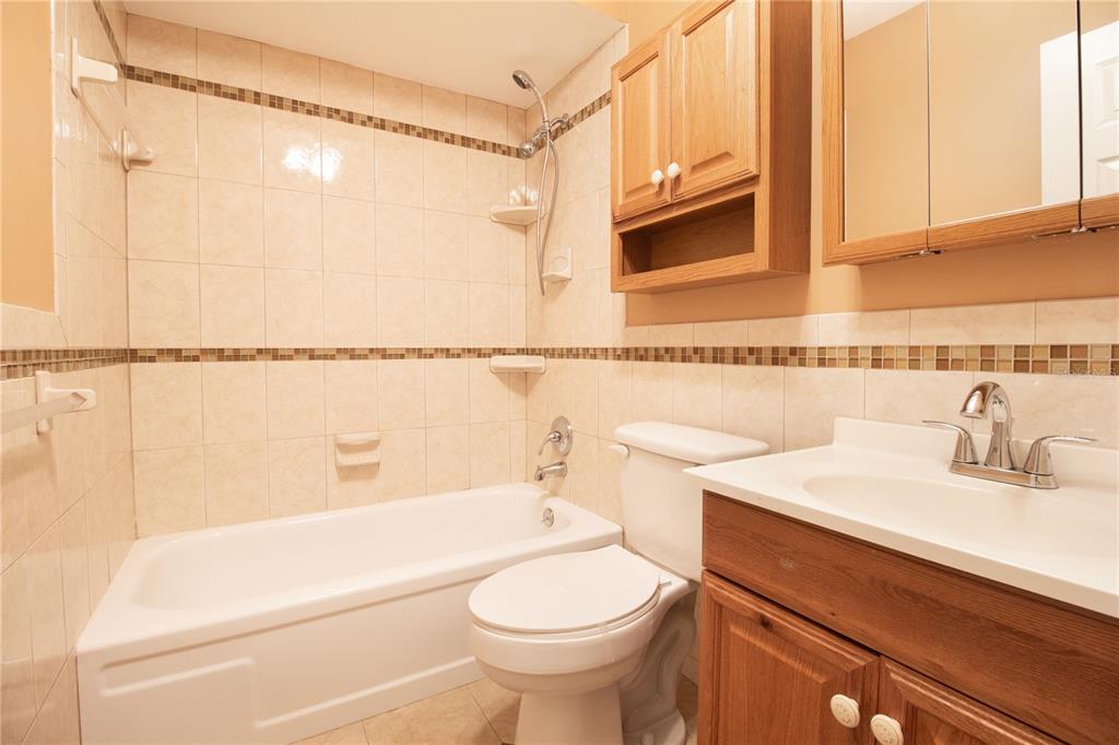 4742 Azalea Drive, Unit 203 New Port Richey, FL 34652 - Photo 18 of 32 a bathroom with a sink a toilet and shower