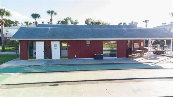 a view of house with swimming pool and chairs