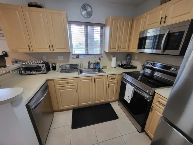 a kitchen with a refrigerator a stove top oven a sink and dishwasher