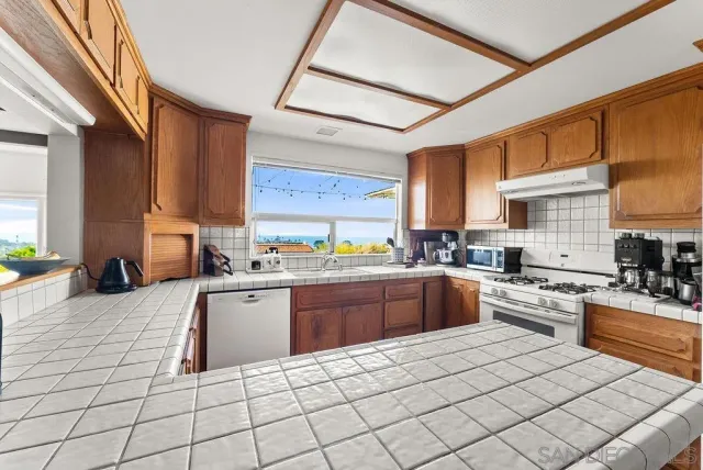 a kitchen with stainless steel appliances granite countertop a stove sink and cabinets
