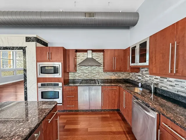 a kitchen with stainless steel appliances granite countertop a sink stove and cabinets
