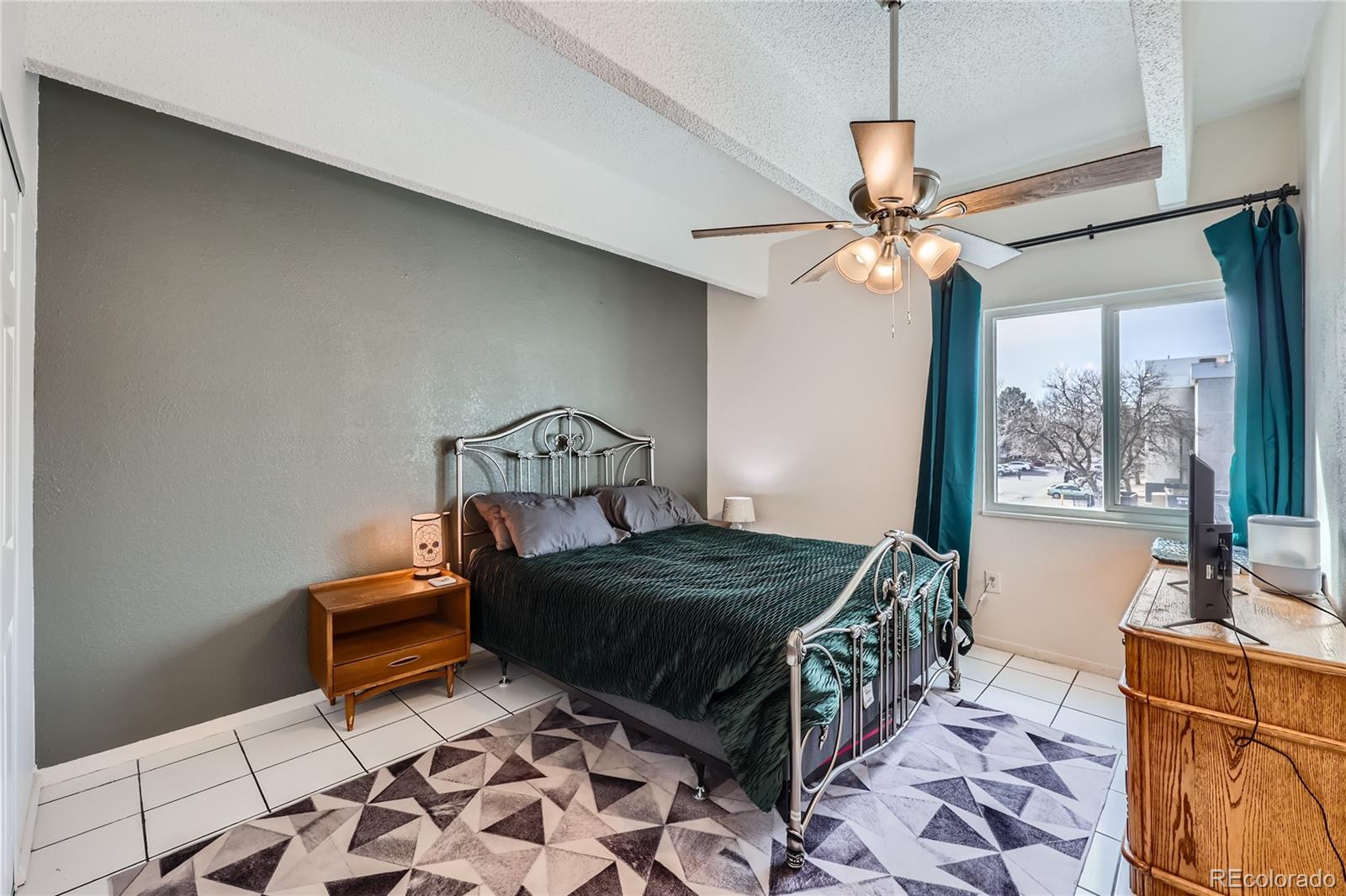 384 South Ironton Street, Unit 314 Aurora, CO 80012 - Photo 5 of 12 a bedroom with a bed and a chandelier