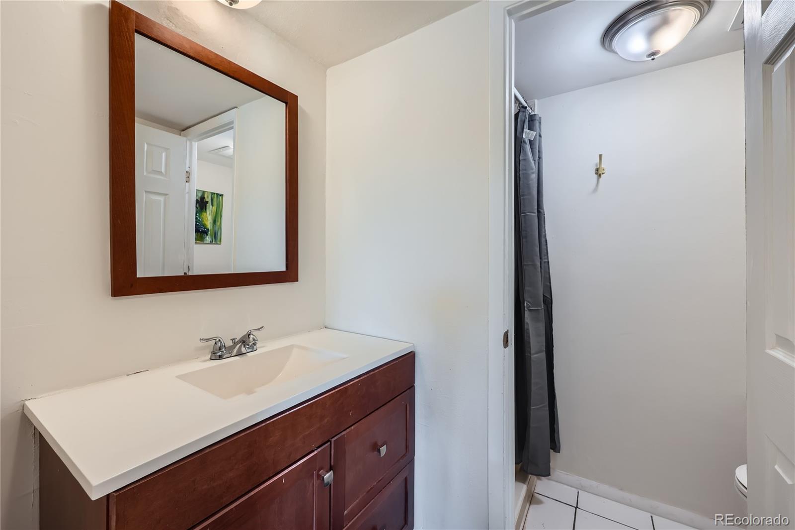 384 South Ironton Street, Unit 314 Aurora, CO 80012 - Photo 8 of 12 a bathroom with a sink vanity and a mirror