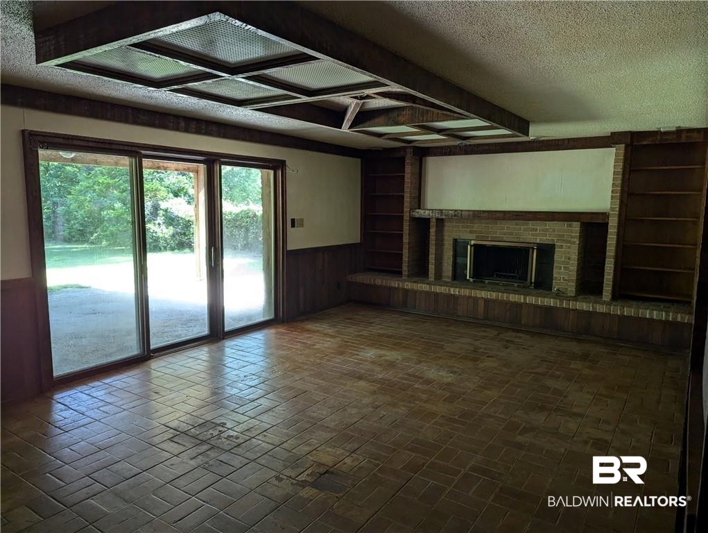 3608 Linden Lane Mobile, AL 36608 - Photo 10 of 20 Unfurnished living room with a textured ceiling, built in features, and a brick fireplace