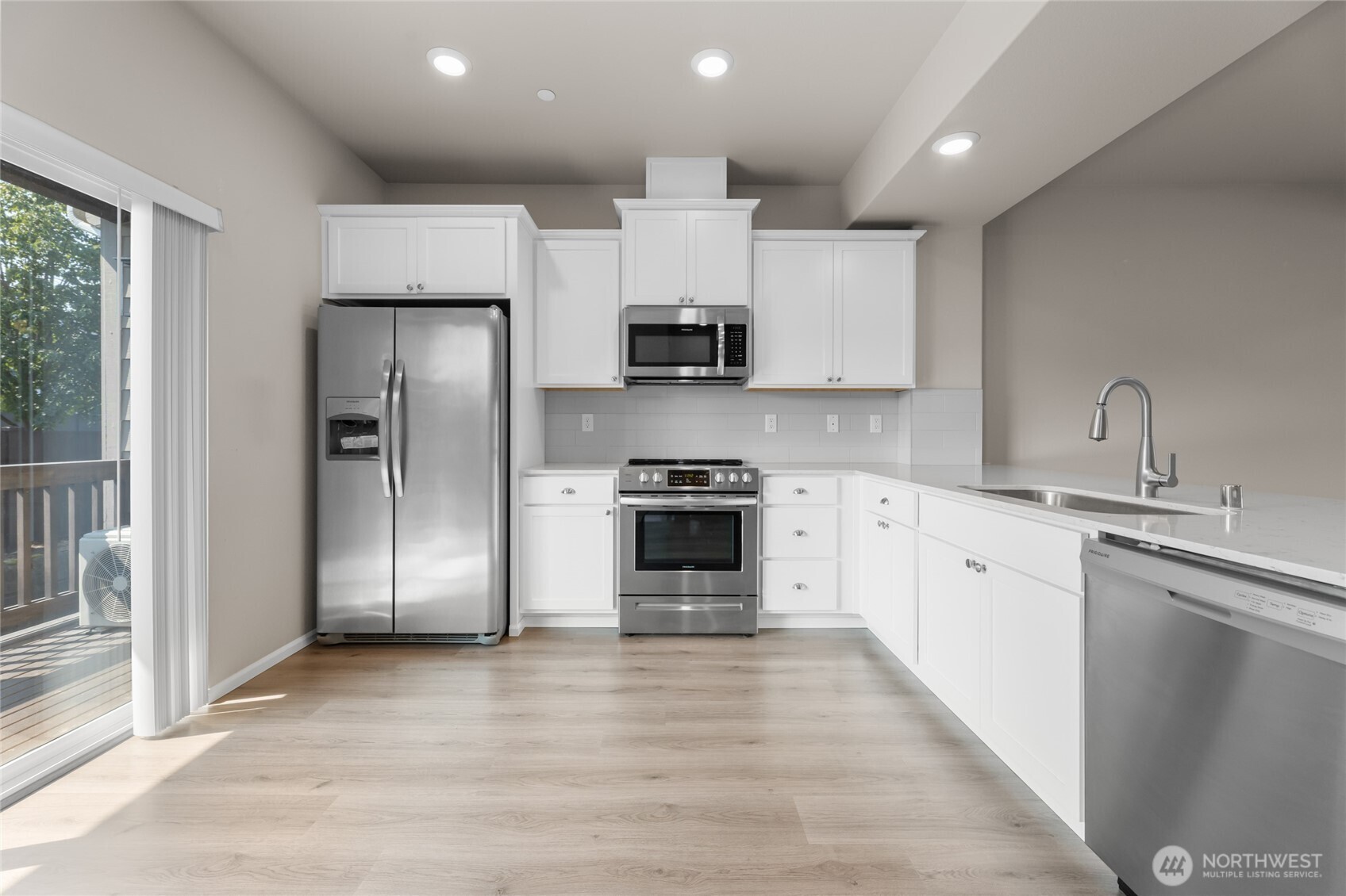 17417 118th Ave Court East, Unit E Puyallup, WA 98374 - Photo 11 of 31 a kitchen with stainless steel appliances a refrigerator sink and stove