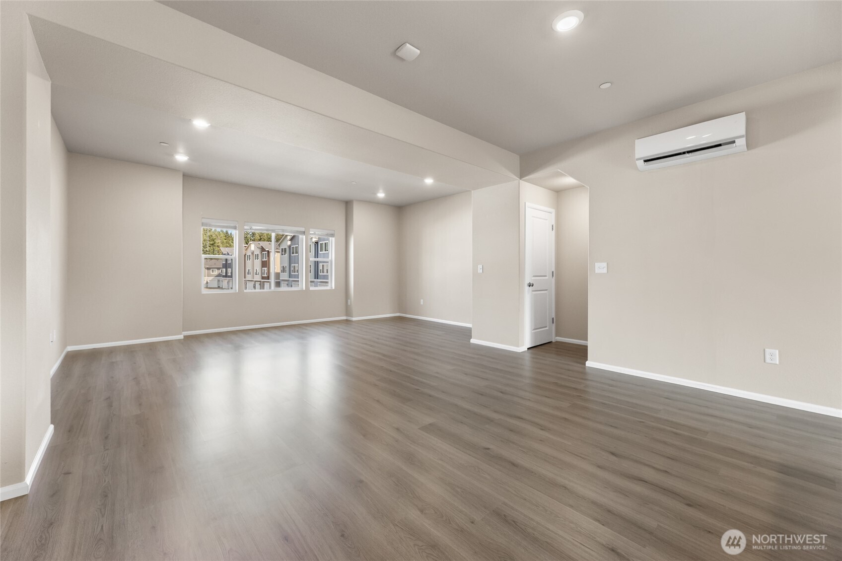 17417 118th Ave Court East, Unit E Puyallup, WA 98374 - Photo 5 of 31 an empty room with wooden floor and windows