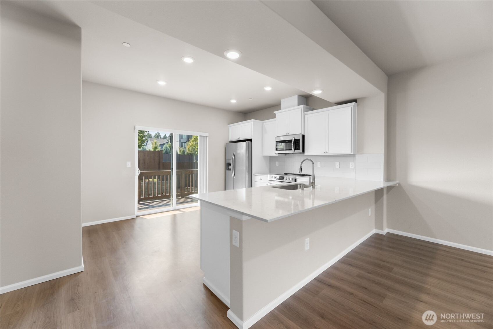 17417 118th Ave Court East, Unit E Puyallup, WA 98374 - Photo 8 of 31 a kitchen with stainless steel appliances a sink stove and wooden floor