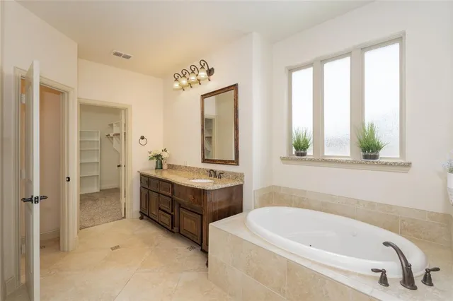 a bathroom with a tub sink and mirror