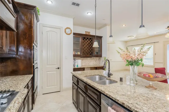 a kitchen with granite countertop a sink a counter top space and cabinets